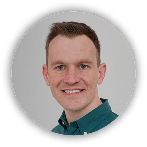 A man wearing a green shirt and smiling. Description generated by AI