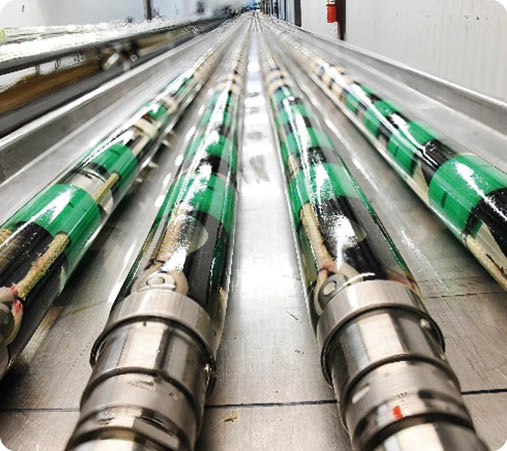 A row of green and black tubes. Description generated by AI