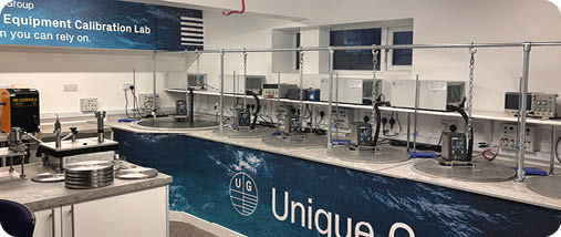 A white counter with a blue and white sign that says Unique Group. Description generated by AI