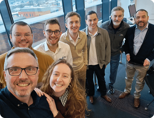 A group of people standing in a room. Description generated by AI
