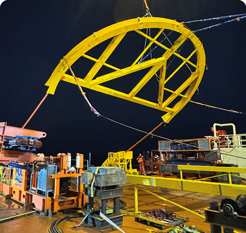 A large yellow structure is being lifted by a crane. Description generated by AI