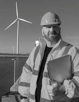 A man in a hard hat is holding a clipboard. Description generated by AI