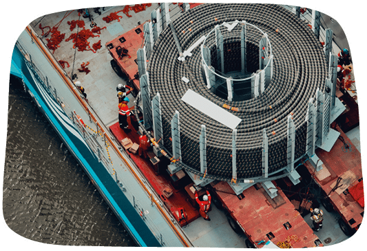A large metal structure is being built on a dock. Description generated by AI