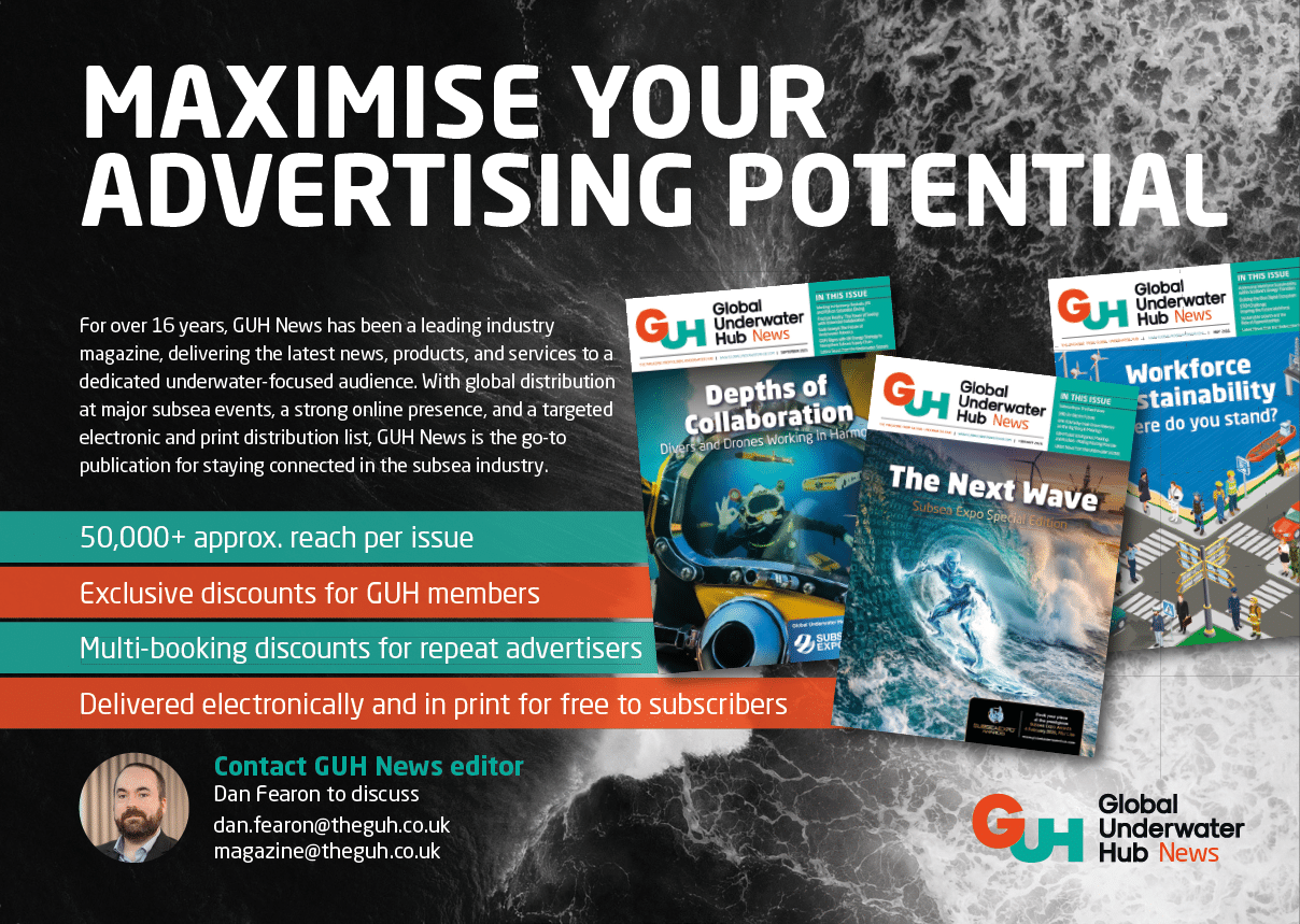 A man is standing in front of a poster advertising GHHub. Description generated by AI